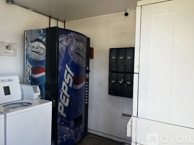 A Pepsi vending machine is in a white room.