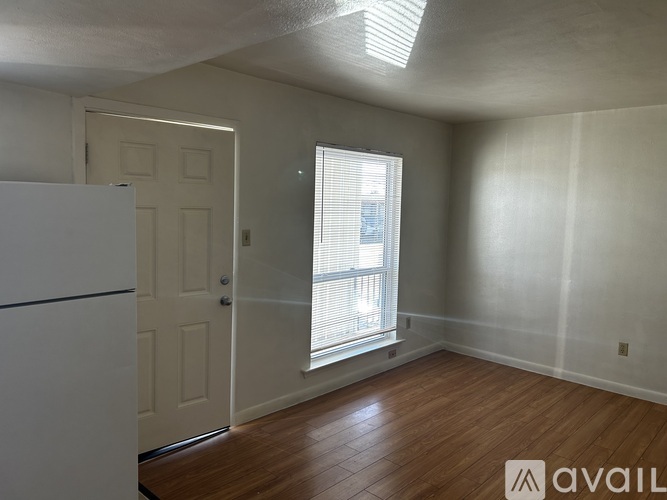A room with a white door and a window with blinds.