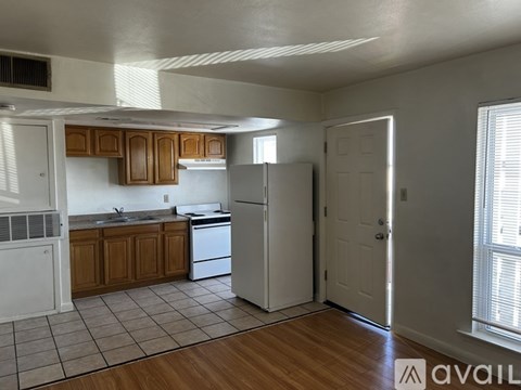 A kitchen with white appliances and wooden cabinets.