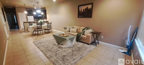 A living room with a couch, chair, and a dining table.