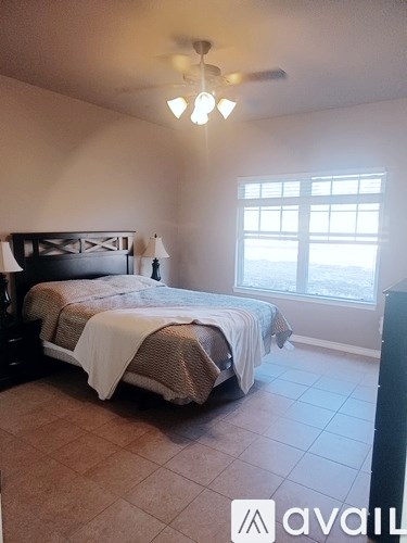 A bedroom with a bed and a window.
