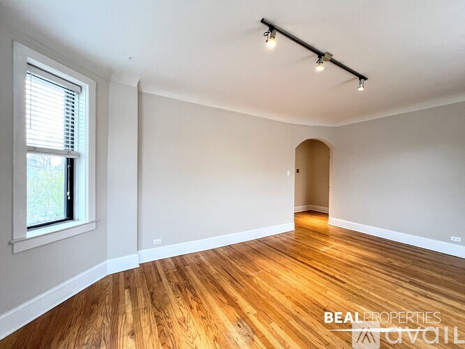 A spacious room with wooden floors and white walls.