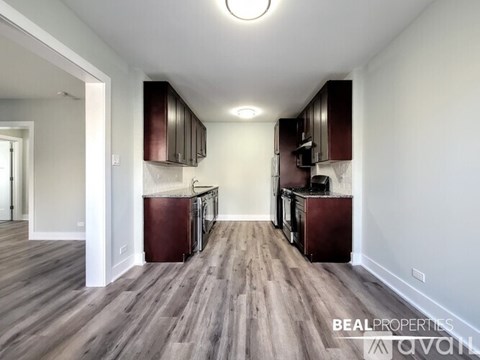 A kitchen with dark wood cabinets and a white wall.