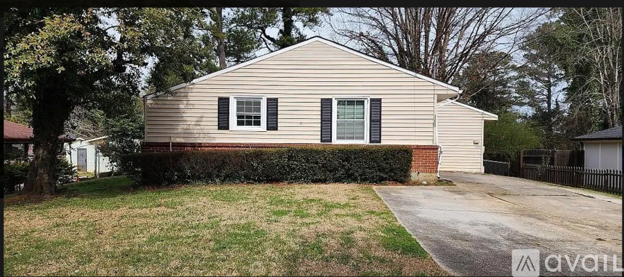 A beige house with a black fence and a green lawn.