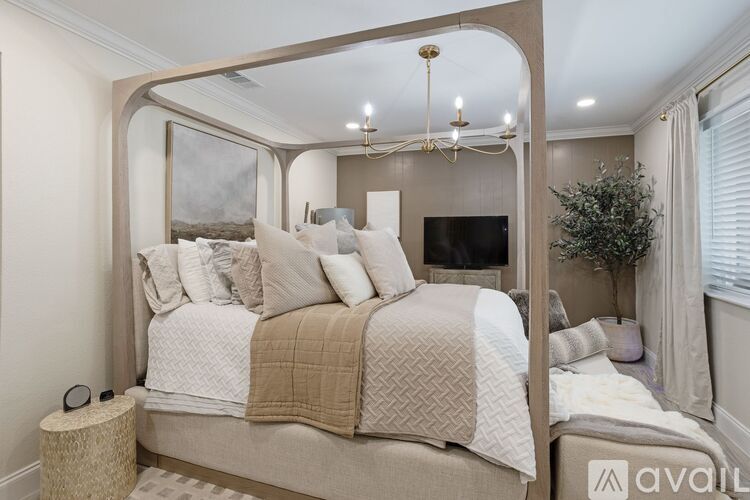 A bedroom with a large bed and a chandelier.