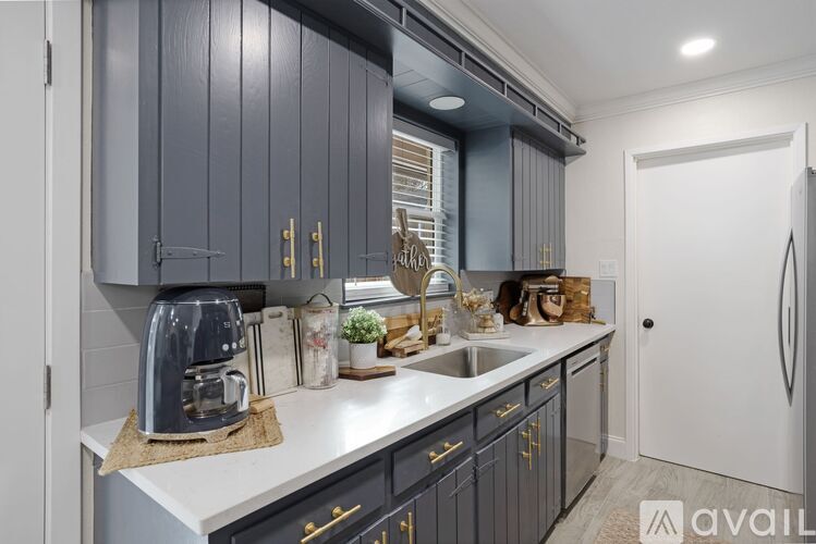 A kitchen with dark grey cabinets and a white countertop.