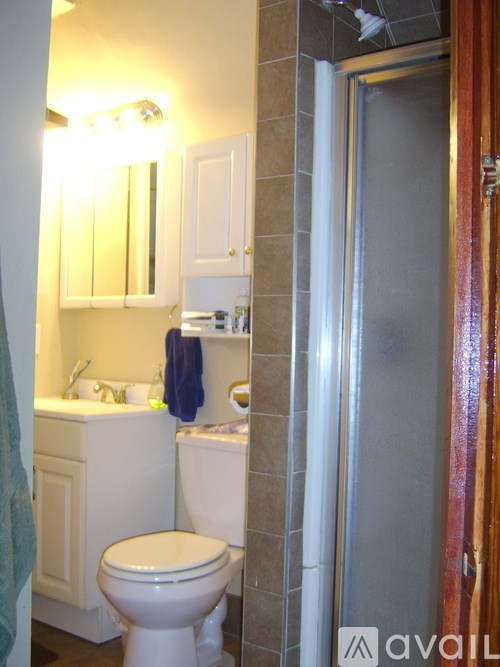 A bathroom with a toilet, sink, and mirror.