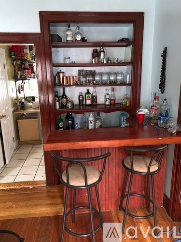 A bar with a wooden floor and a red wall.
