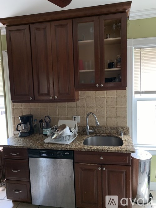 A kitchen with brown cabinets and a granite countertop.