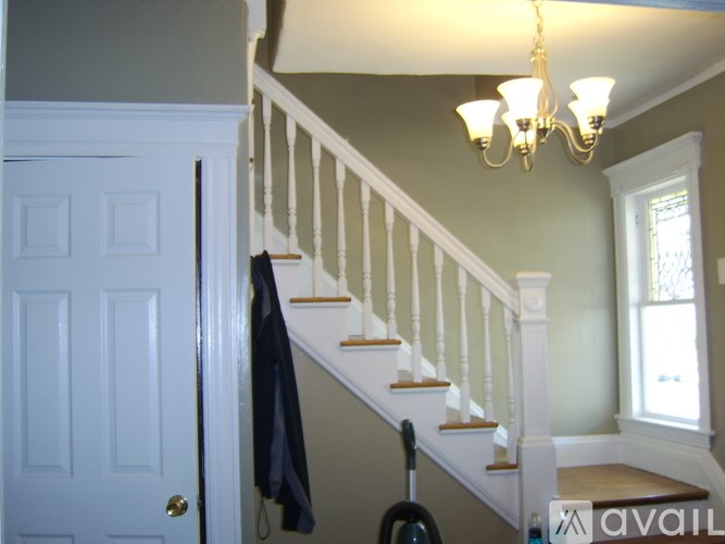 A staircase with a chandelier hanging above it.