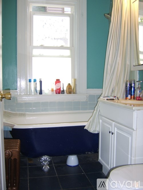A bathroom with a blue tub and a white sink.
