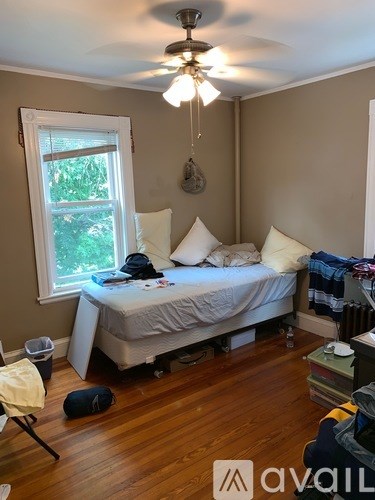 A bedroom with a bed, window, and a ceiling fan.