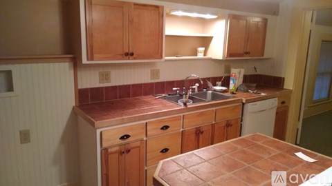 A kitchen with wooden cabinets and a tiled backsplash.