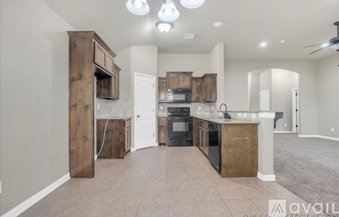 A kitchen with wooden cabinets and a countertop is available for rent.