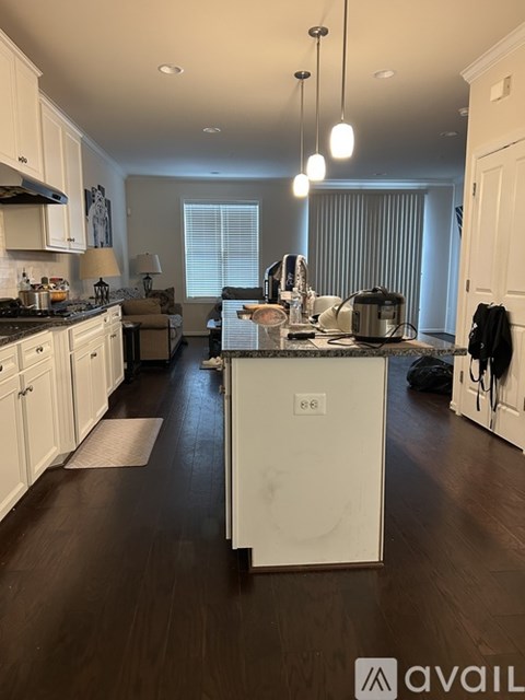 A kitchen with white cabinets and a black stove top.