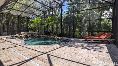 A pool surrounded by a glass wall with trees in the background.