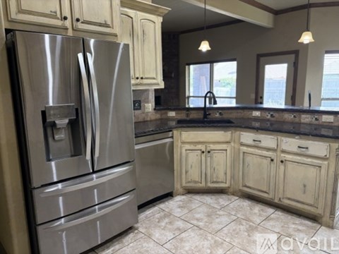 A kitchen with a stainless steel refrigerator and wooden cabinets.