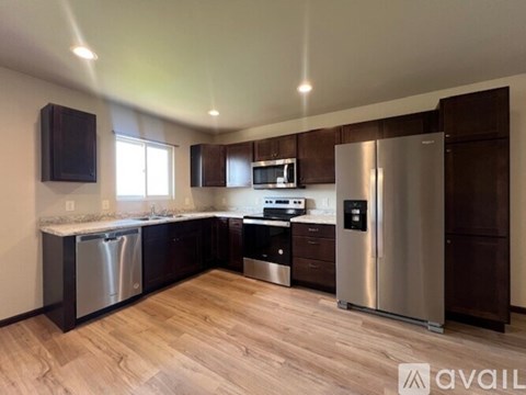 A kitchen with dark wood cabinets and stainless steel appliances.