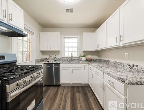 A kitchen with white cabinets and a black stove top.
