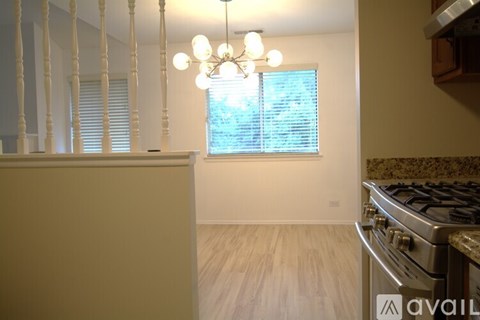 A kitchen with a stove and a window with blinds.