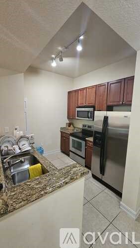 A kitchen with a granite countertop and stainless steel appliances.