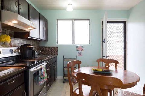 A kitchen with a table and chairs.