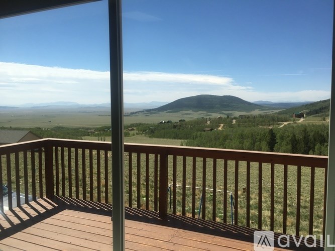 A wooden deck with a view of a valley.