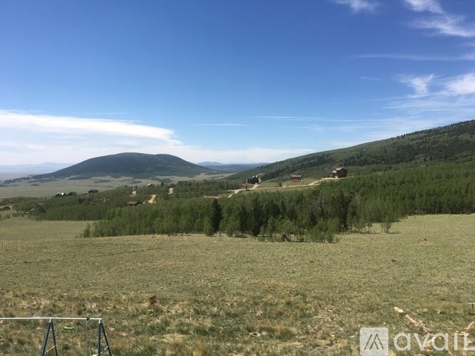 A landscape with a mountain in the distance and a clear blue sky.