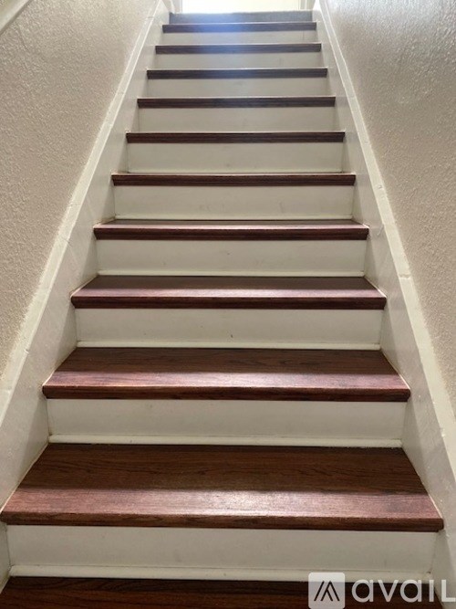 A set of stairs with white risers and dark brown treads.