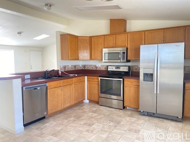 A kitchen with wooden cabinets and a tile backsplash.