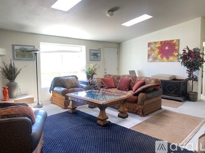 A living room with a couch, chair, and a table.