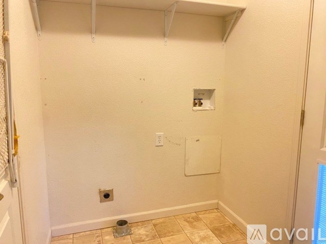 A bathroom with a toilet and a white wall.