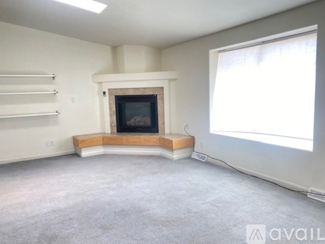 A living room with a fireplace and a window.