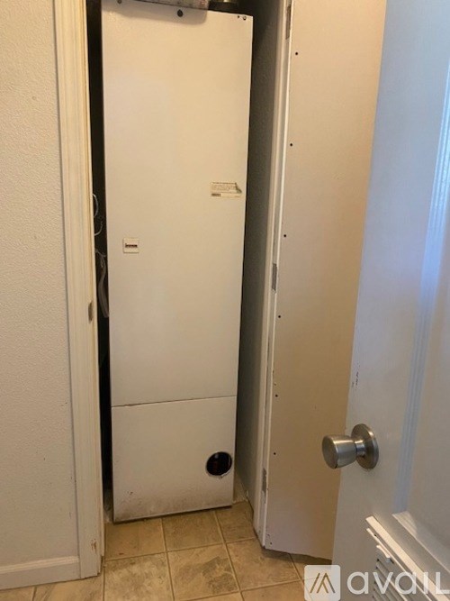 A white door is open to a small room.