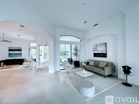 A modern living room with a black sofa and a white coffee table.