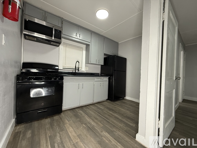 A kitchen with black appliances and white cabinets.
