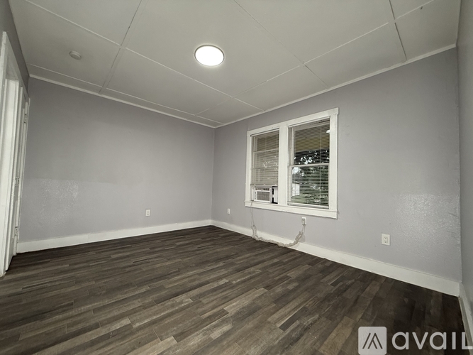 A room with wooden flooring and a window.