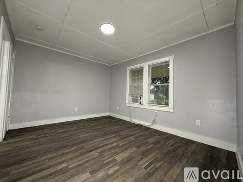 A room with wooden flooring and a window.