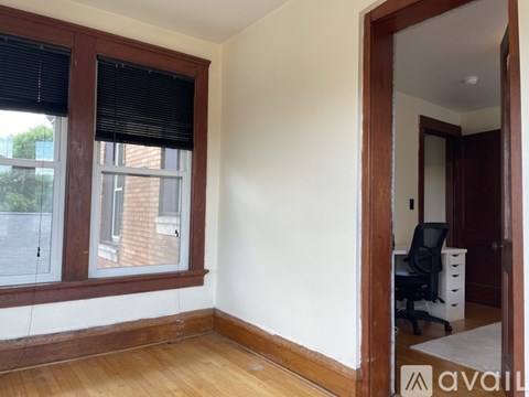A room with a window and a desk with a chair.
