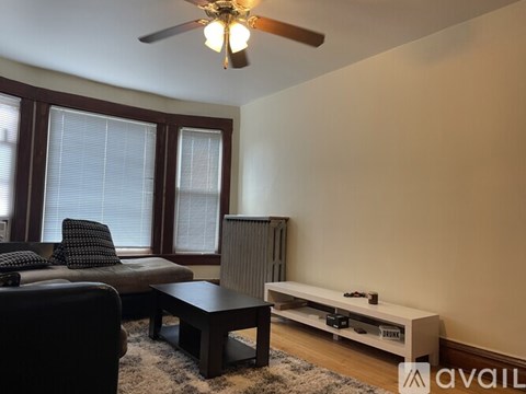 A living room with a black couch, a brown coffee table, and a flat screen TV.