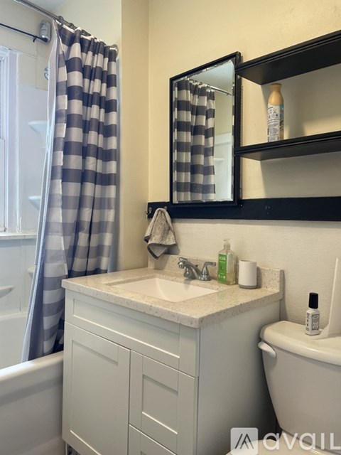 A bathroom with a sink, mirror, and toilet.