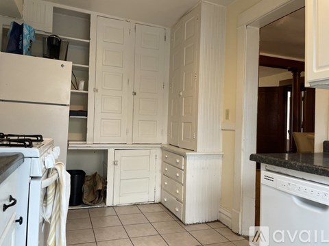 A kitchen with white appliances and cabinets.