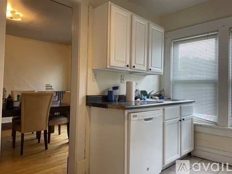 A kitchen with white cabinets and a dishwasher.