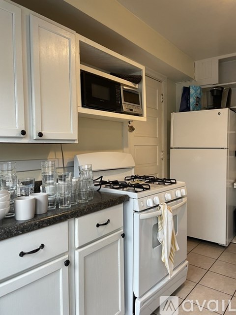 A kitchen with a white stove and cabinets.