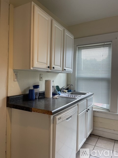 A kitchen with white cabinets and a black countertop.