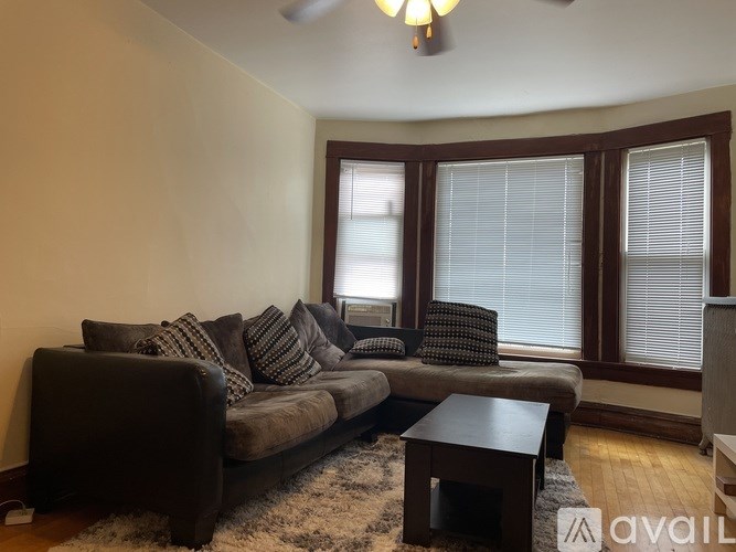A living room with a brown couch and a coffee table.