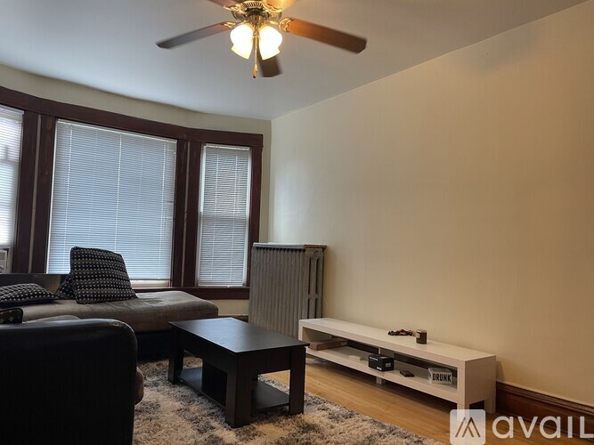 A living room with a black couch, a brown coffee table, and a flat screen TV.