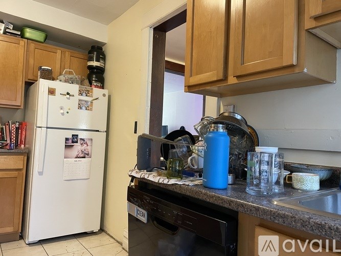 A kitchen with a white fridge and wooden cabinets.