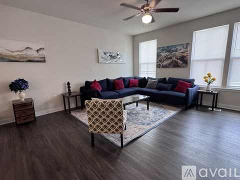 A living room with a blue couch and a rug.