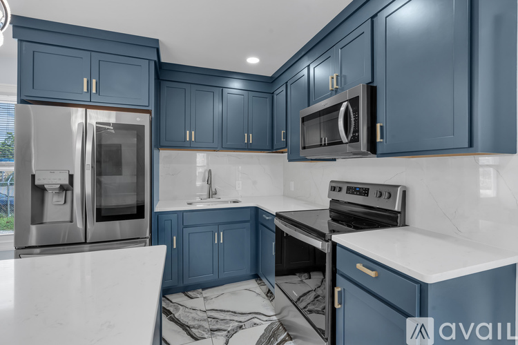 A kitchen with blue cabinets and white countertops is under renovation.